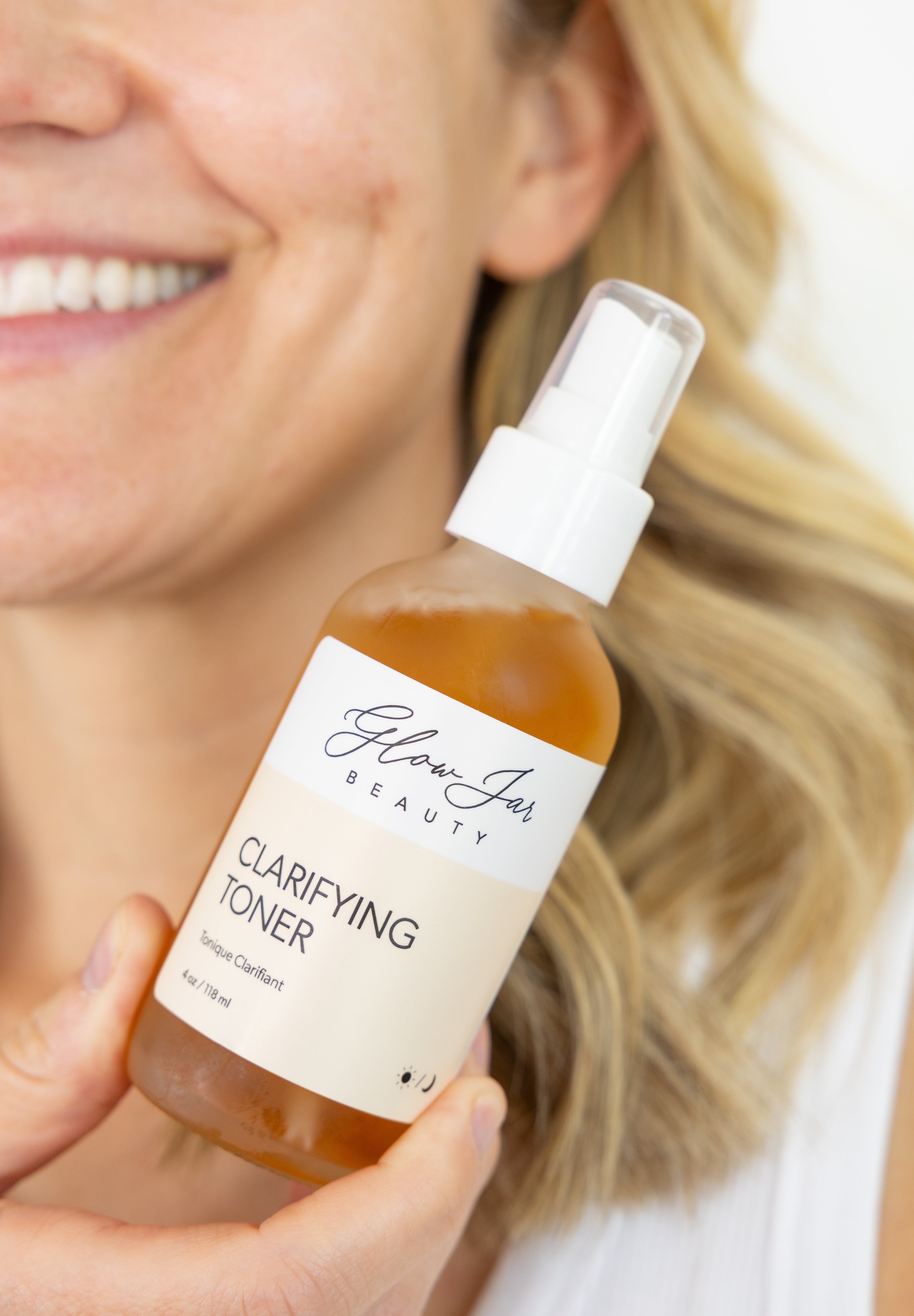 Bottle of Glow Jar Beauty Clarifying Toner held by a person with a blurred background