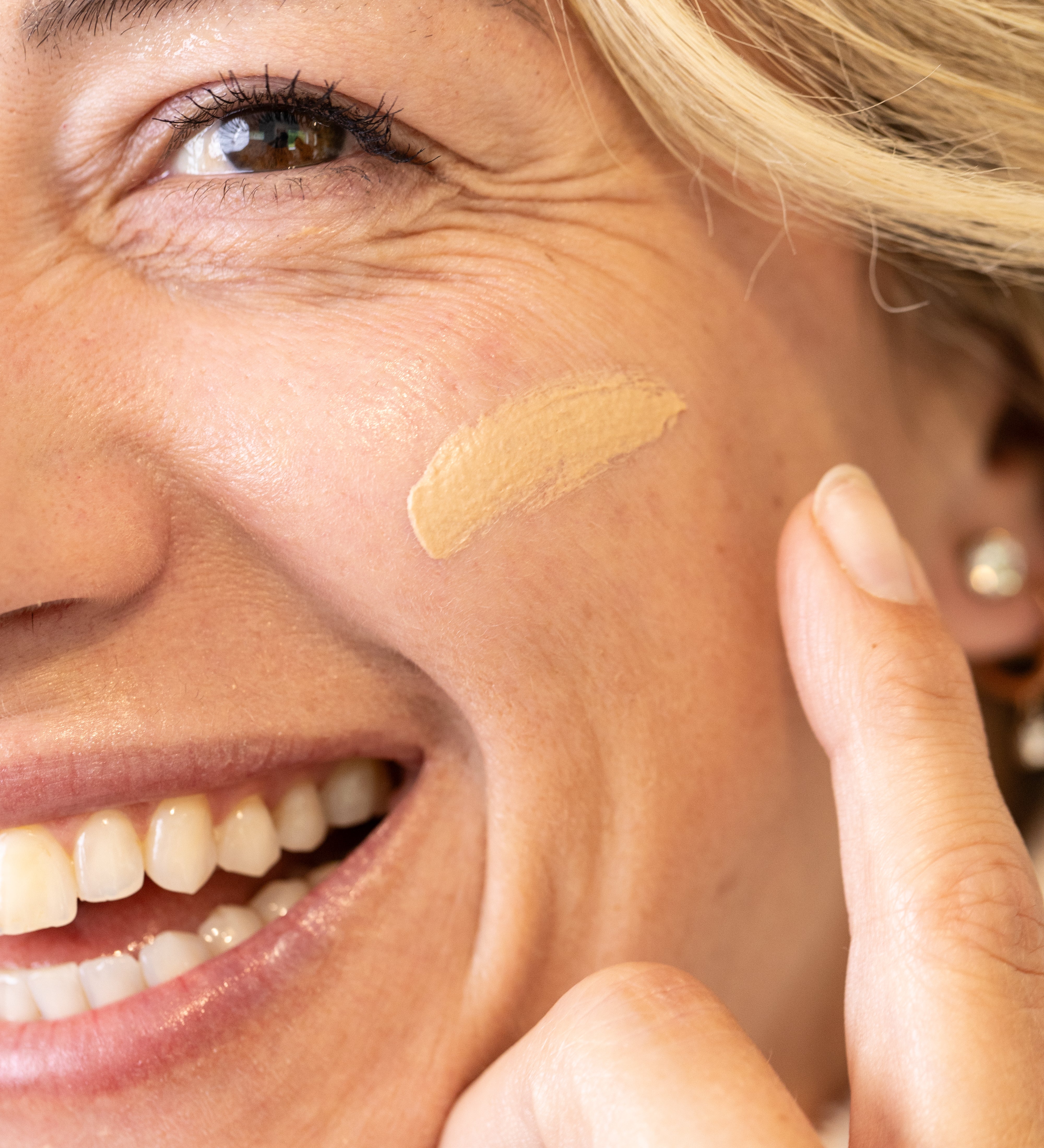 Woman applying a glow jar beauty tinted SPF 30 to her face with a finger
