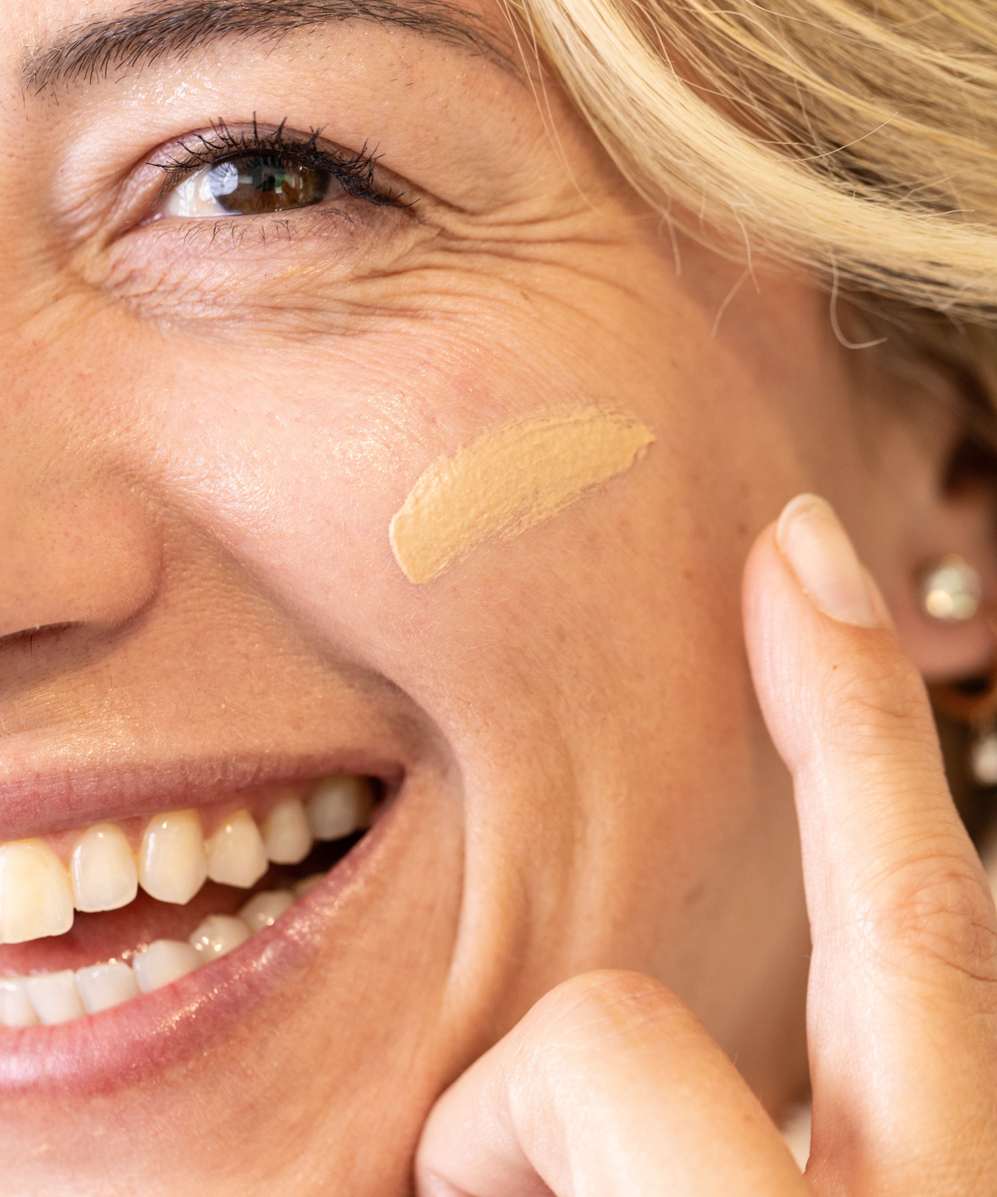 Woman applying a glow jar beauty tinted SPF 30 to her face with a finger
