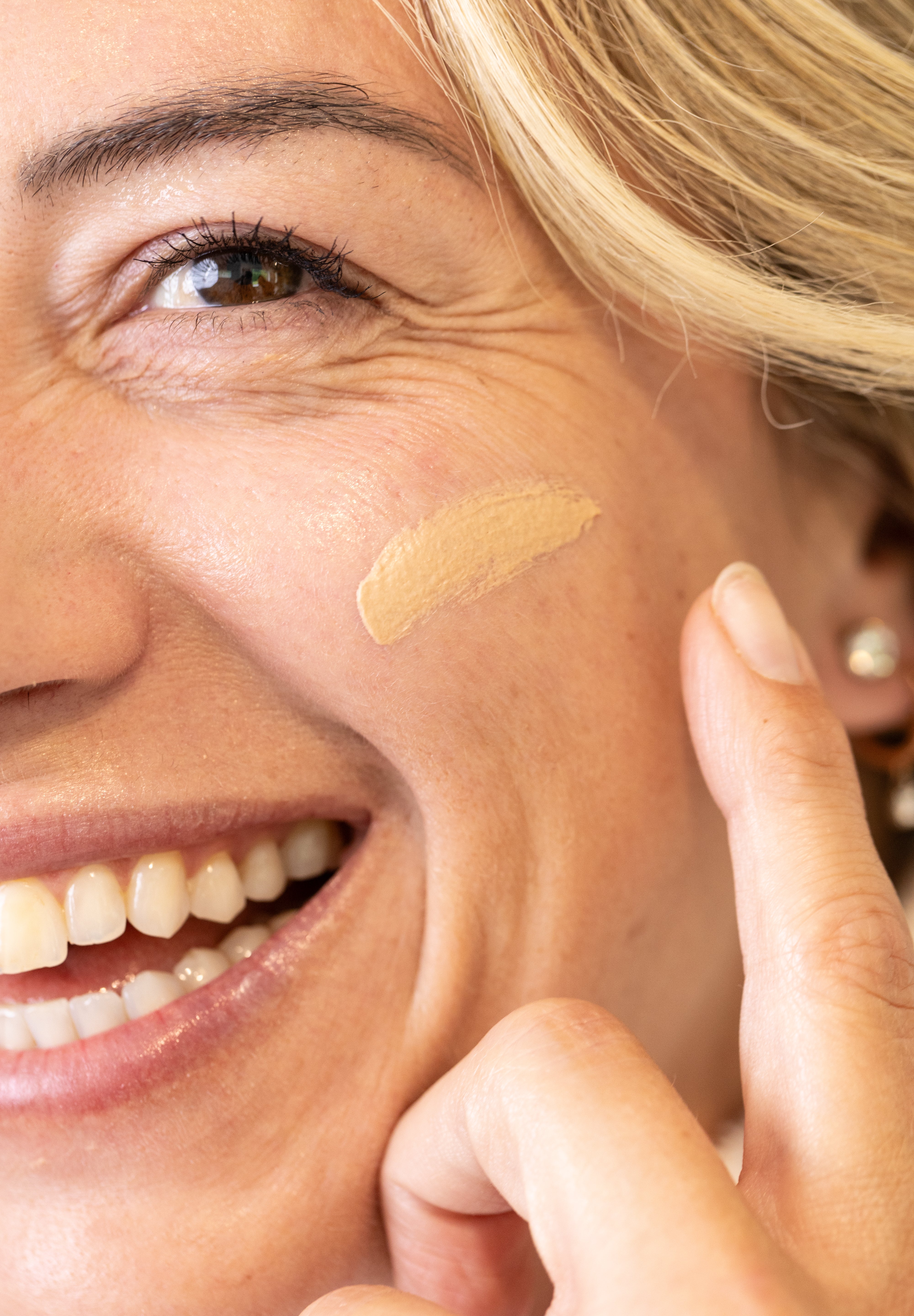 Woman applying a glow jar beauty tinted SPF 30 to her face with a finger