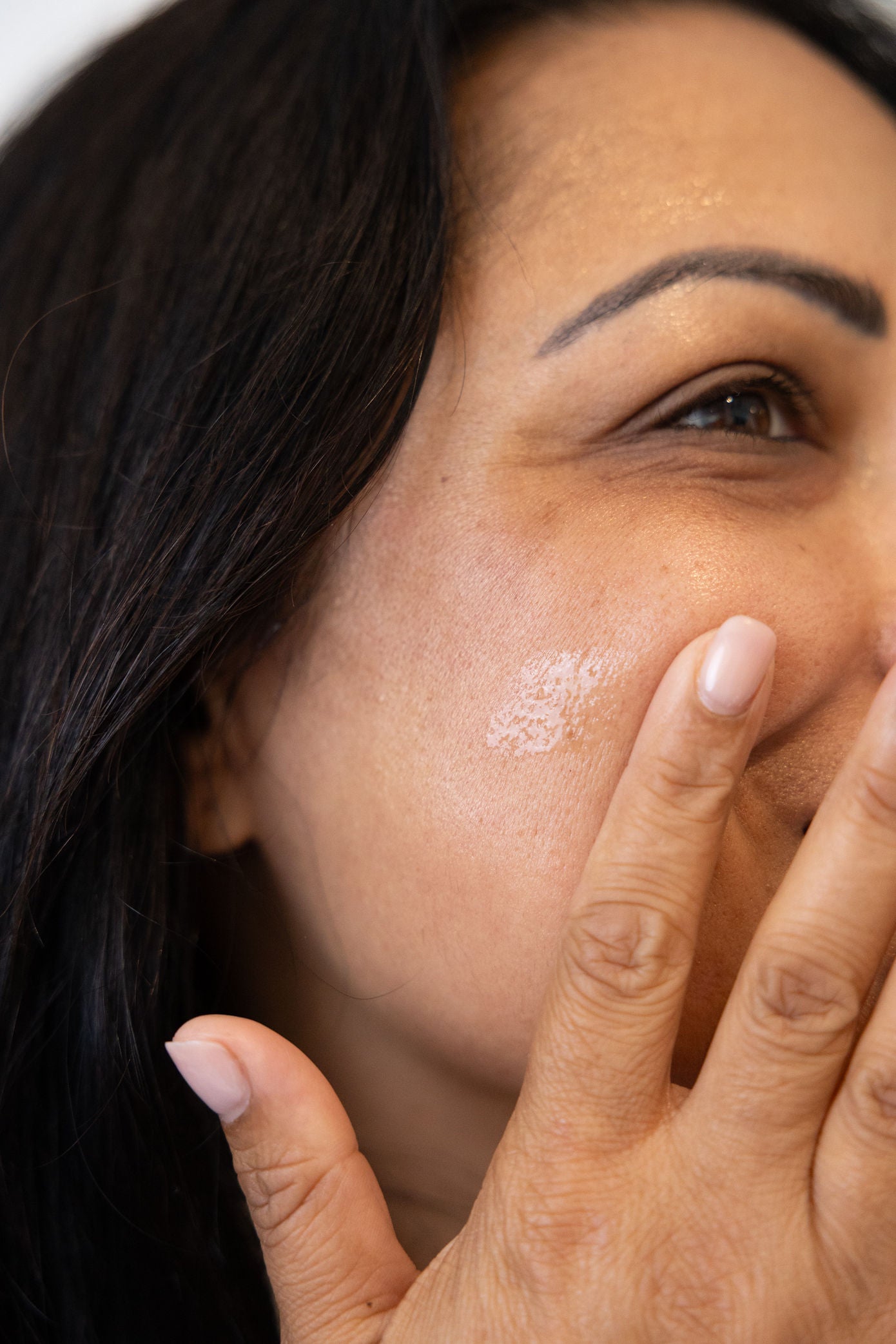 Close-up of a woman's face rubbing in Vitamin C serum