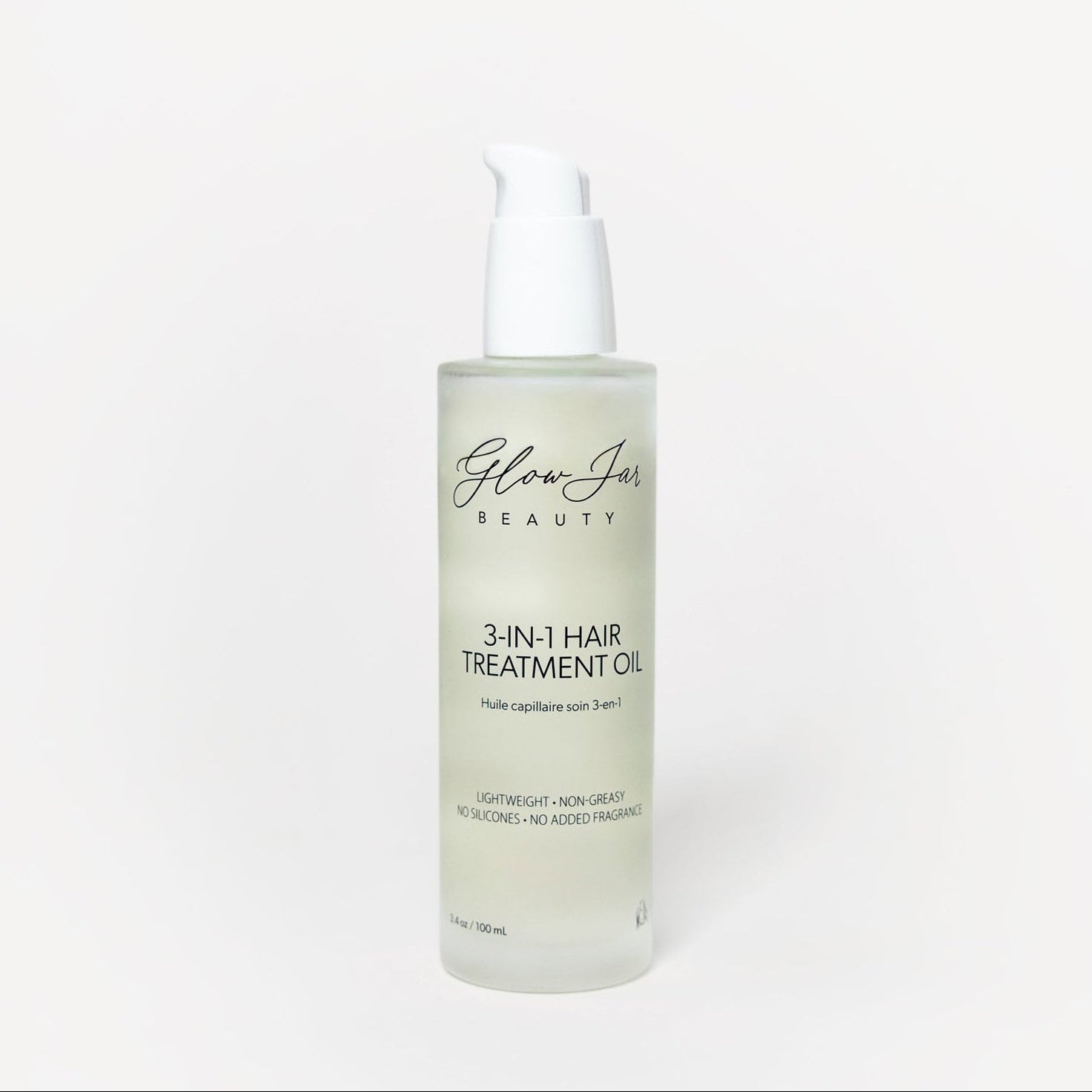 Glass bottle of 3-in-1 hair treatment oil on a white background