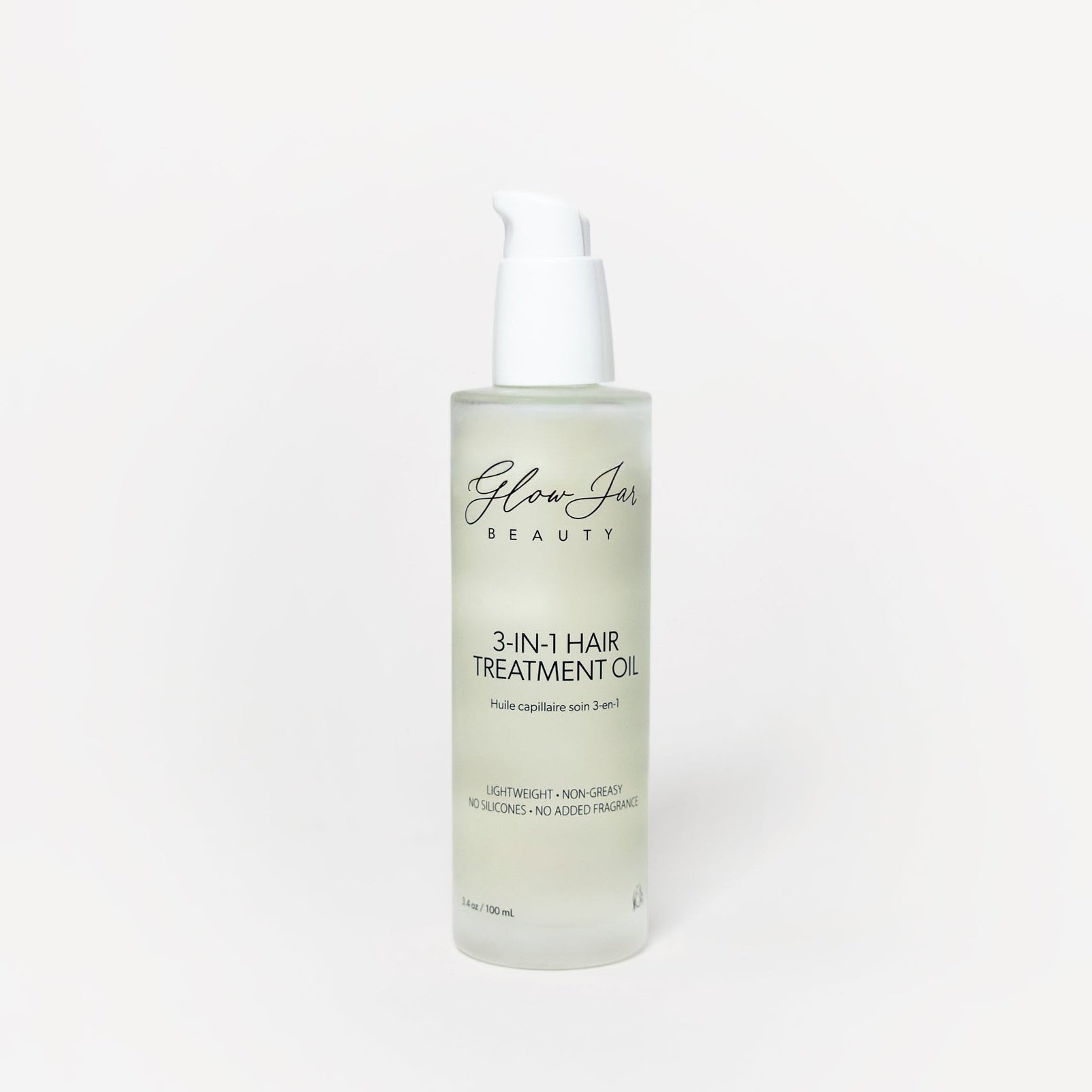 Glass bottle of 3-in-1 hair treatment oil on a white background