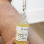 Bottle of Glow Jar Beauty Fragrance Free Body Oil being applied to skin.