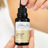 LuminousFacialOil woman holding bottle GlowJarBeauty