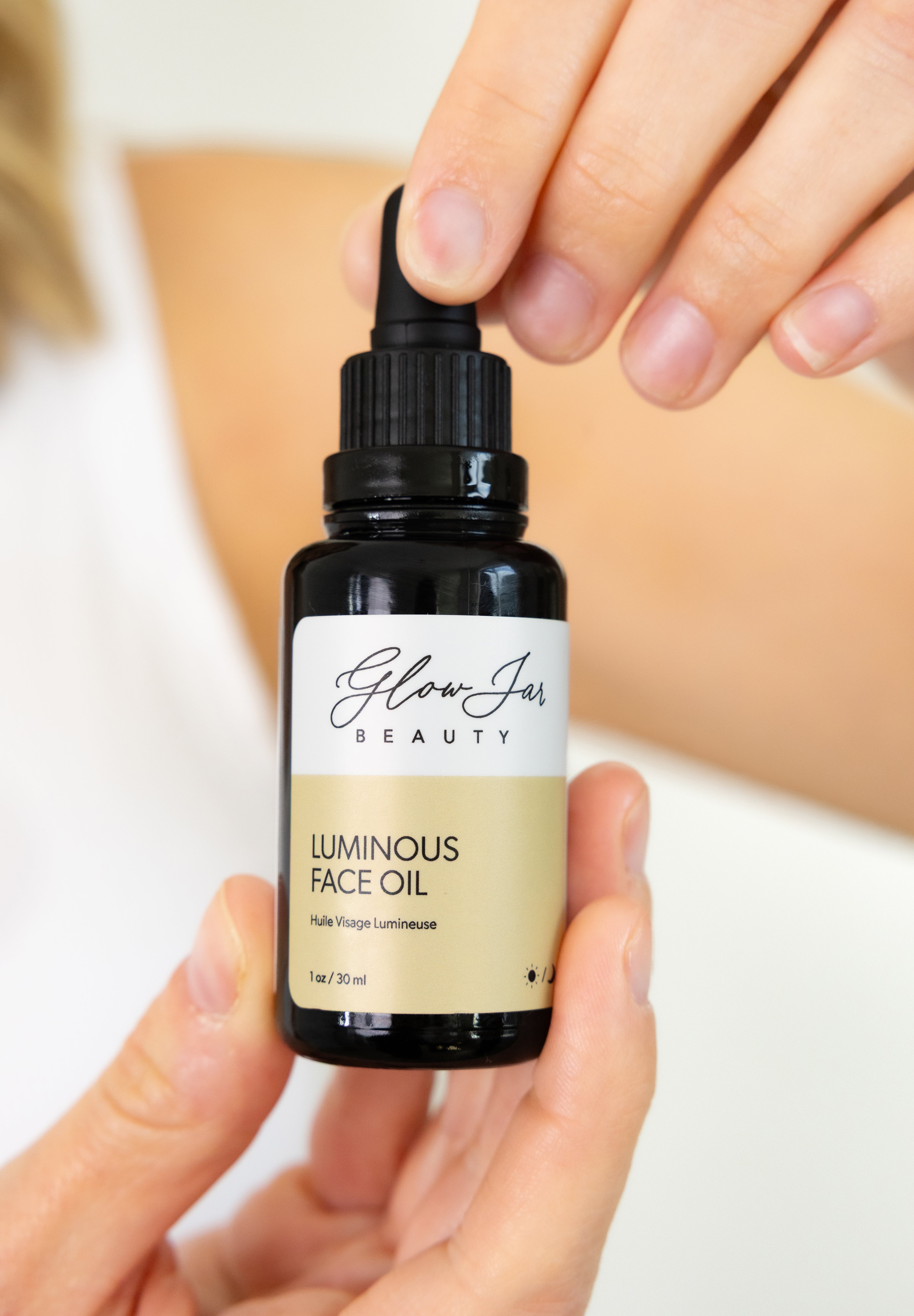 LuminousFacialOil woman holding bottle GlowJarBeauty
